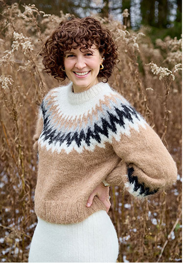 woman with curly hair smiling outdoors